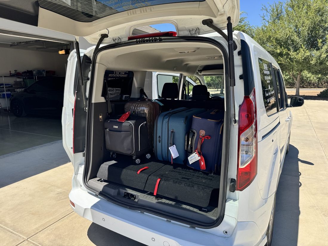 Suitcases arranged in the rear cargo area of the van